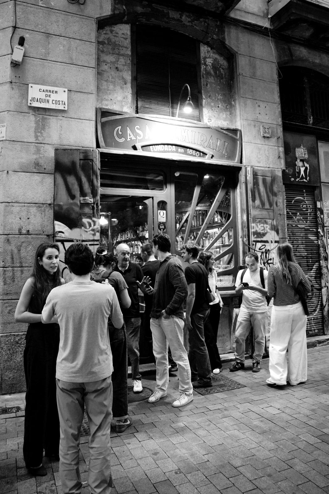 Gent conversant a la porta de la Casa Almirall, al carrer de Joaquín Costa